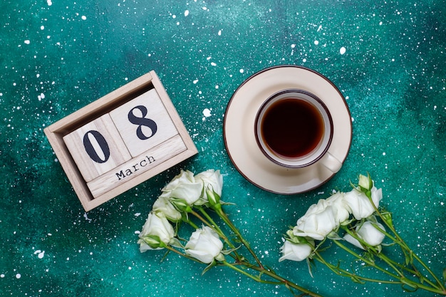 March 8 Women's Day card with white flowers,sweets and a cup of tea