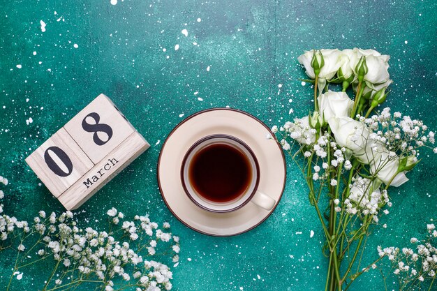 March 8 Women's Day card with white flowers,sweets and a cup of tea