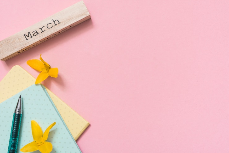 Free Photo march inscription with yellow flowers and notebooks