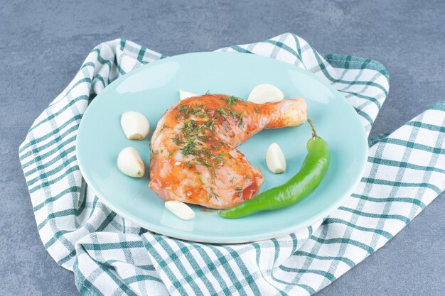 青いプレートにニンニクとコショウでマリネした鶏肉。