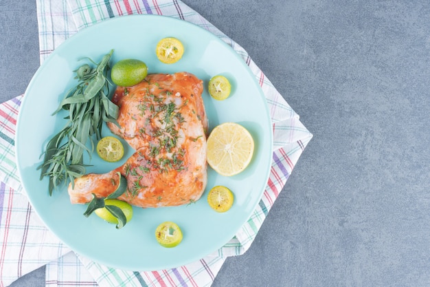 Free photo marinated chicken with lemonnd tarragon on blue plate.