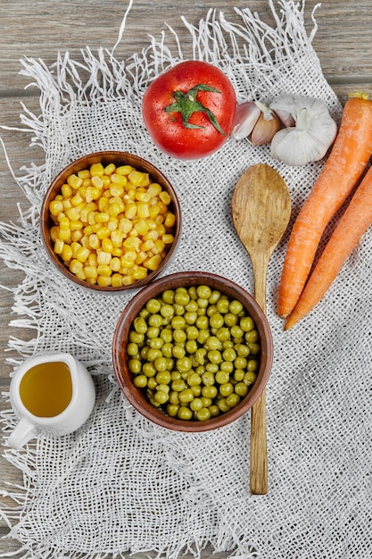 Free photo marinated corn and green pea beans in wooden cups.