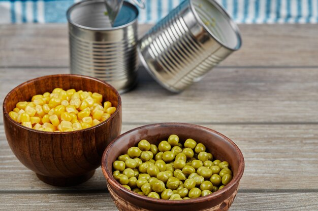 Free photo marinated green pea beans and corns in wooden cups.