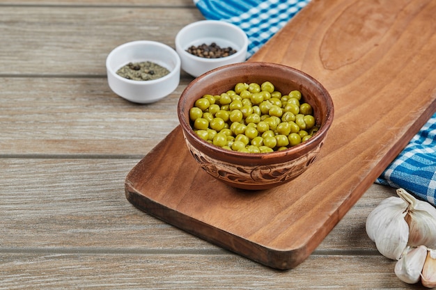 Foto gratuita fagioli verdi marinati in una tazza di legno.