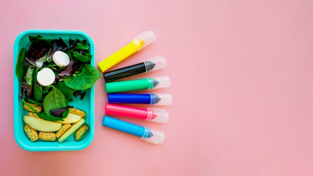 Marker pens lying near salad