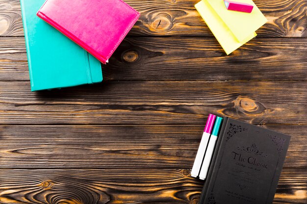 Markers and notebooks on wooden tabletop