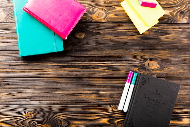 Markers and notebooks on wooden tabletop