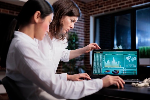 Free photo marketing agency employees discussing about bankruptcy while analyzing financial data on laptop screen. business company office workers sitting at desk while reviewing startup project state.