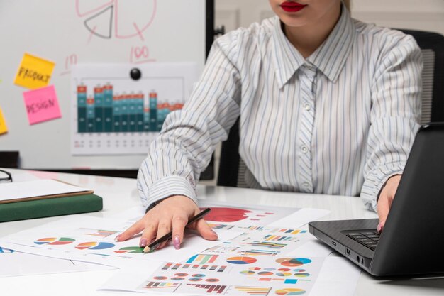Marketing business lady in striped shirt in office with glasses on desk understanding charts