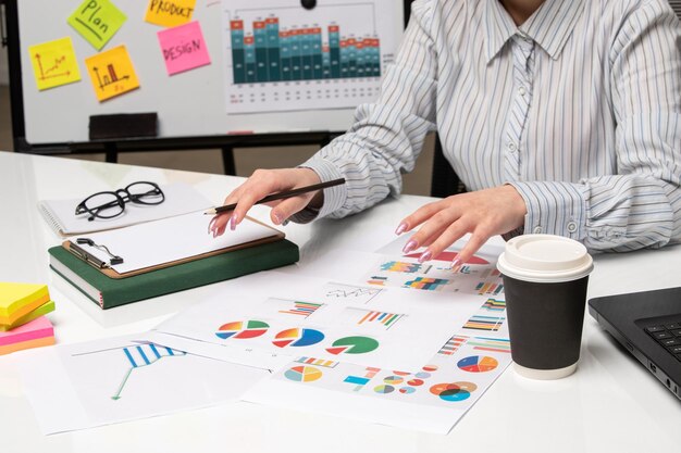 Marketing business lady in striped shirt in office with glasses on desk working with coffee cup