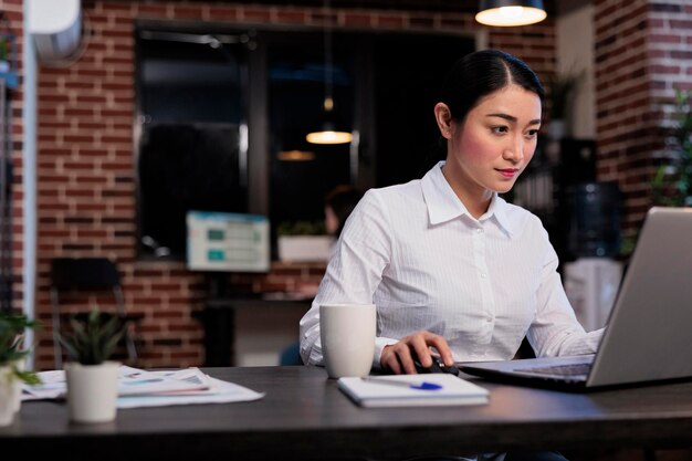 Marketing company employee sitting at desk in office while developing management plan. Executive manager working on computer laptop while analyzing accounting data and financial strategy.