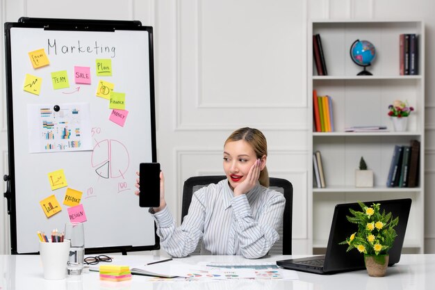 Marketing smart cute business lady in striped shirt in office looking at cell phone