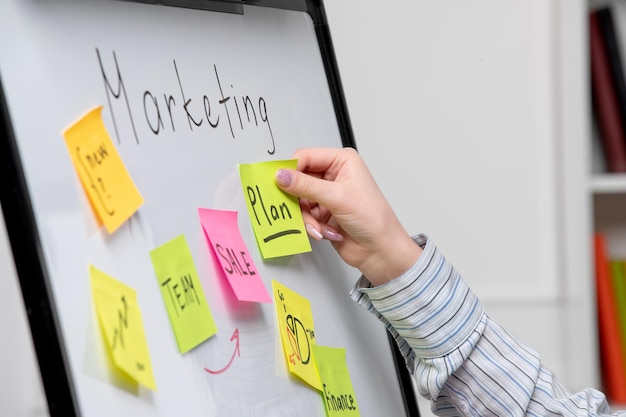 Marketing young cute business lady in striped shirt in office creating new marketing plan