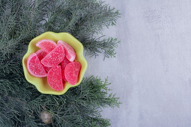 Marmalade bowl nested on pine branches on white background.