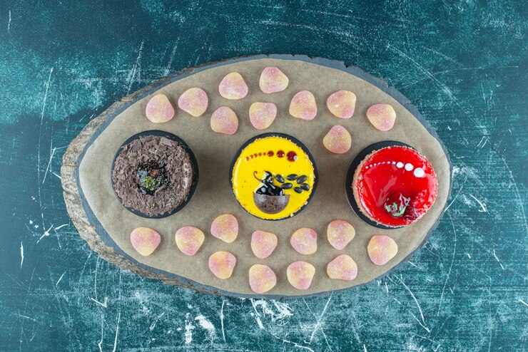 Free Photo marmelades and cakes bundled up on a wooden board on blue.