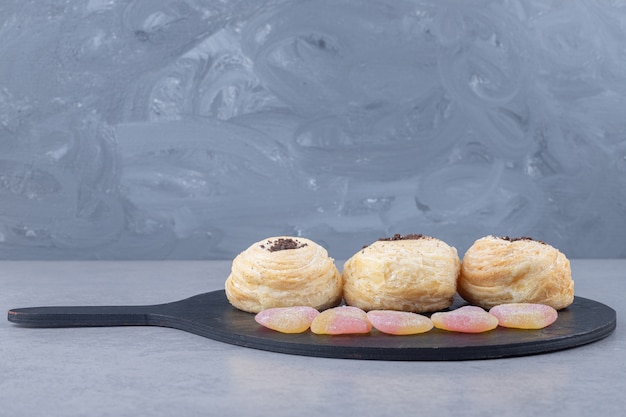 Free photo marmelades and flaky cakes on a black board on marble table.