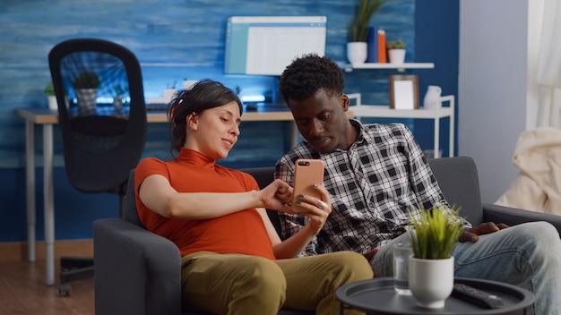 Married interracial couple relaxing on living room sofa