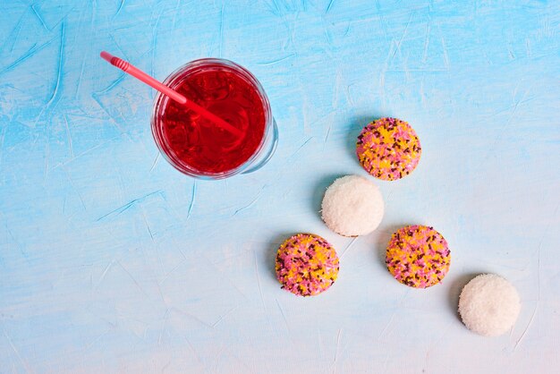 Marshmallow cookies with a glass of juice on blue background. 