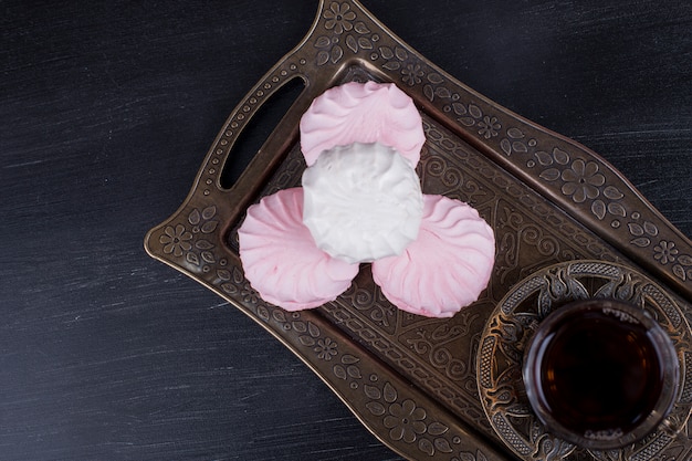 Foto gratuita marshmallow con un bicchiere di tè, vista dall'alto