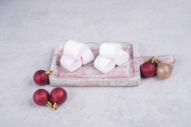 Marshmallows on wooden board with Christmas balls. High quality photo