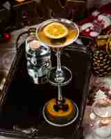 Free photo a martini glass of alcohol drink with black olive and lemon slice