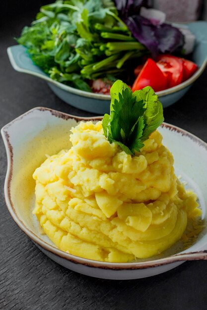 Mashed potatoes served with fresh vegetables and greens