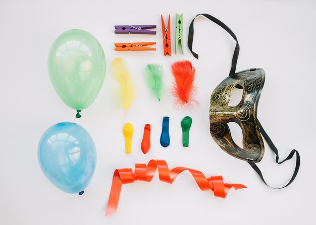 Бесплатное фото Маска возле воздушных шаров, ленты и булавок