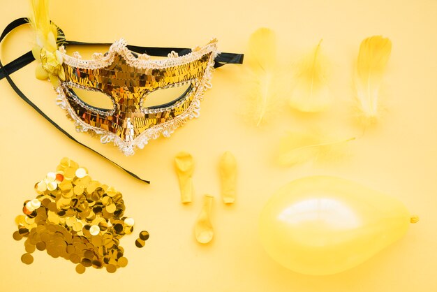 Mask near glitters, balloons and feathers