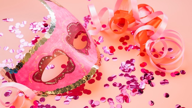 Free photo mask near ribbons and set of rose glitters