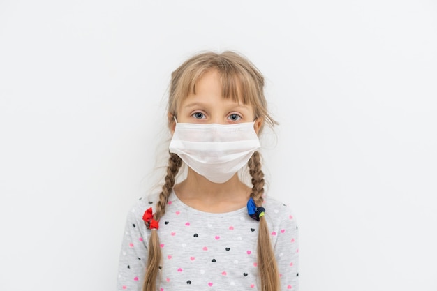 가면을 쓴 아이 - 인플루엔자 바이러스에 대한 보호. pm2.5를 보호하기 위해 마스크를 쓴 백인 소녀. 생물학 무기. 복사 공간이 있는 회색 배경에 있는 아기. 감염병 유행 감염병 세계적 유행.