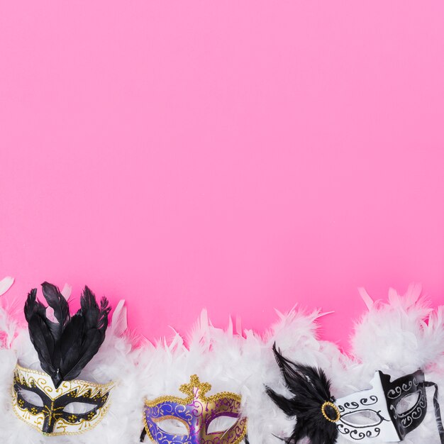 Free photo masks on white feathers