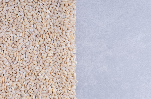 Mass of rice neatly arranged on marble surface