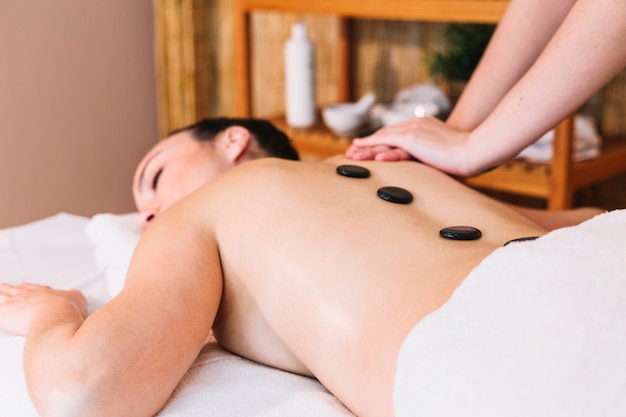 Massage concept with stones on womans back