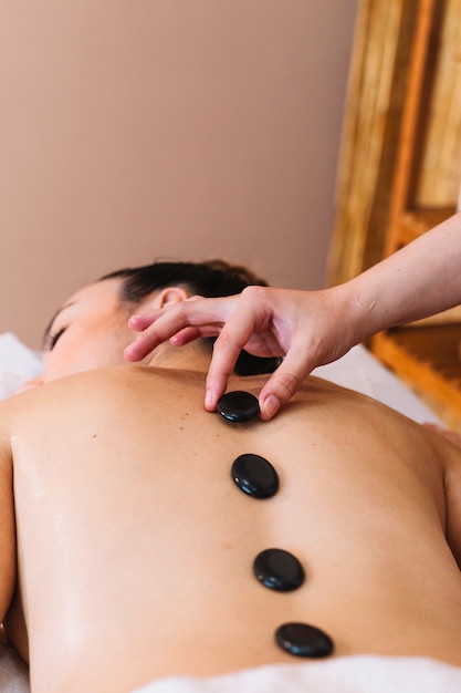 Free photo massage concept with stones on womans back