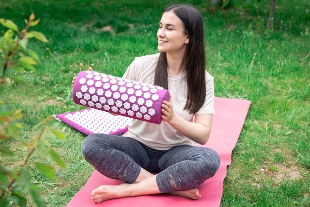 Free photo massage mat for relaxation and treatment in female hands in the garden