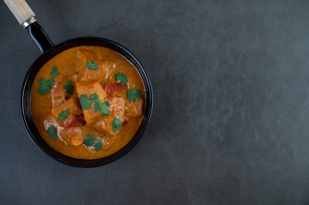 Massaman curry in a frying pan on the cement background