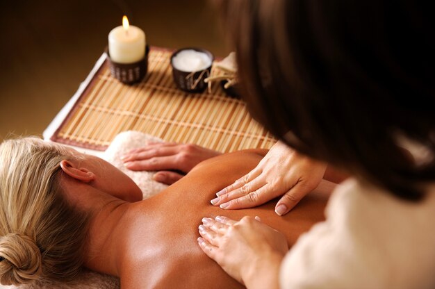 Masseur doing  massaging  backbone of woman in spa salon