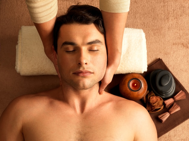Masseur doing neck massage on man in the spa salon.