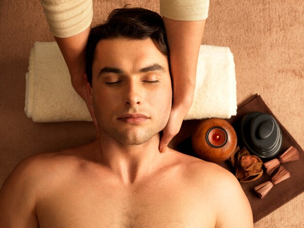 Masseur doing neck massage on man in the spa salon.