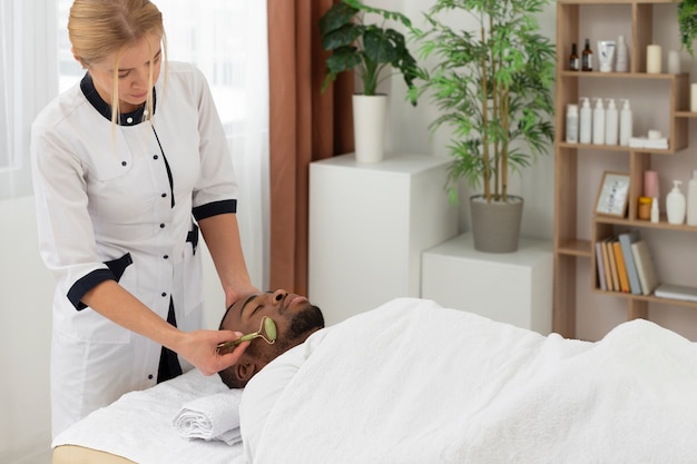 Foto gratuita massaggiatrice che si prende cura del suo cliente