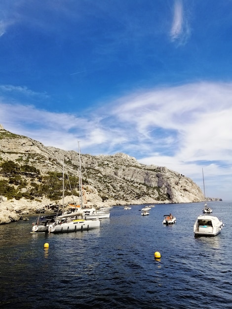 프랑스 마르세유의 햇빛 아래에서 보트로 둘러싸인 대산 괴 des Calanques