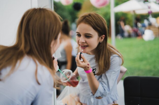 マスタークラスメークアップ。女の子は彼女の友達にメイクをする