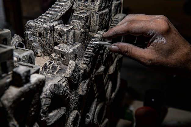 Master cleaning ancient stone sculpture