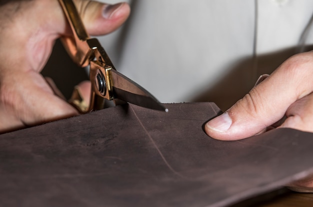 Free photo master cutting leather for tailoring.