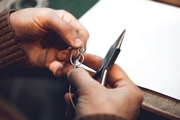 Master making jewelry from metallic thread.