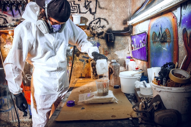 Maestro pittore in una fabbrica - pittura industriale del legno con pistola a spruzzo.