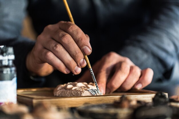 Master painting a gesso sculpture. High quality photo