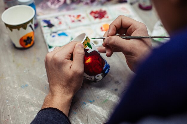 Master painting on a plastic cup