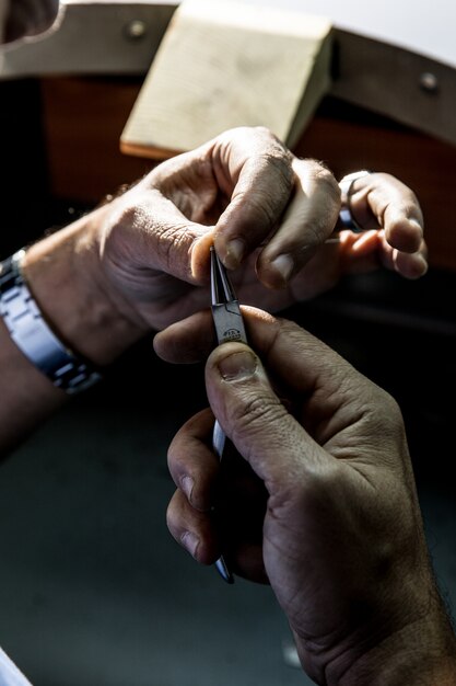 Master using metallic tools to create a jewelry piece