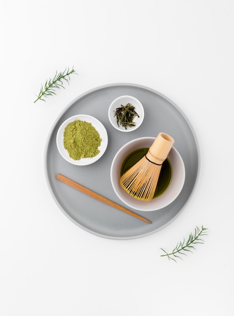 Matcha tea concept on a tray with bamboo whisk